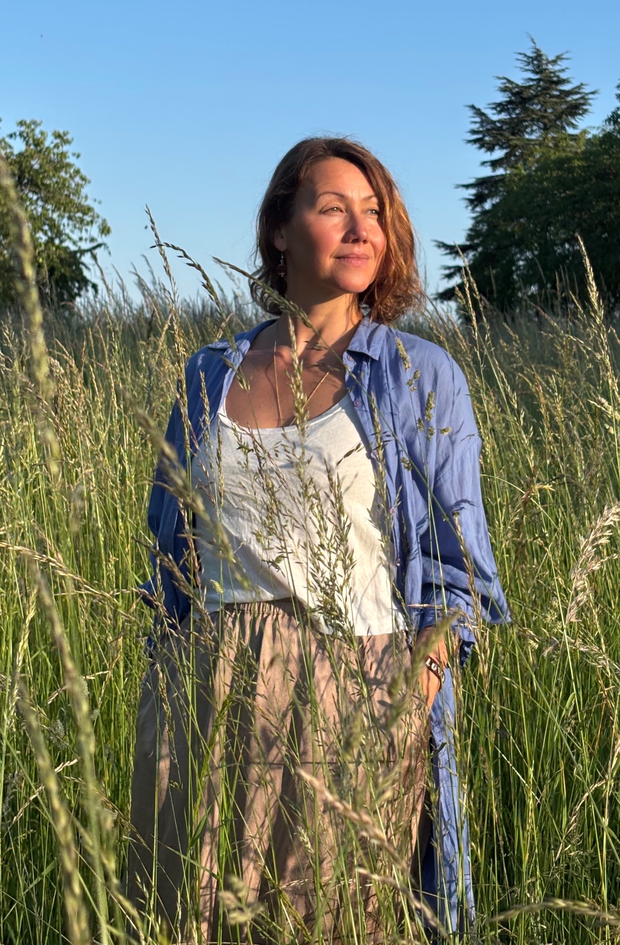 Irina Schmidt steht in hohem Gras unter blauem Himmel